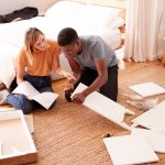 Couple In New Home Putting Together Self Assembly Furniture