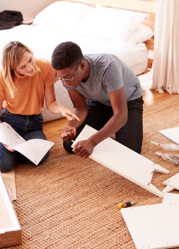 Couple In New Home Putting Together Self Assembly Furniture